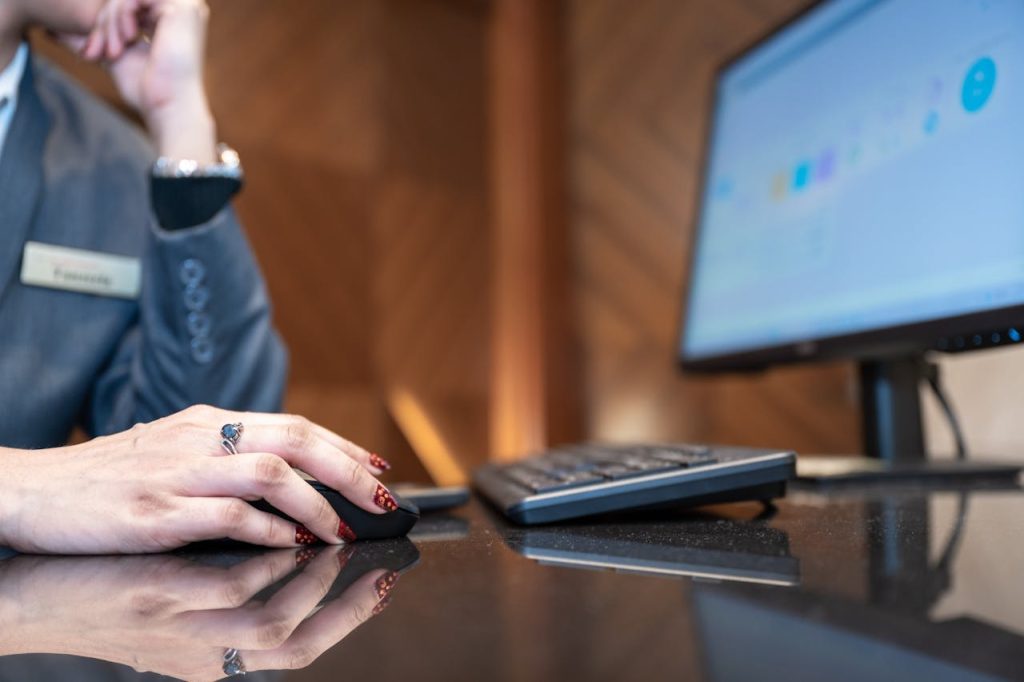 Close-up of a business professional using a computer mouse and keyboard in a modern office environment.